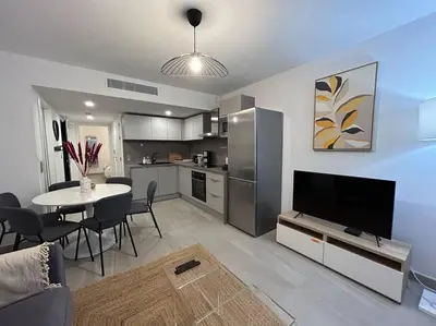 a living room with a kitchen and a table with a television at Prestige View 411 By Avecoeur in Èze