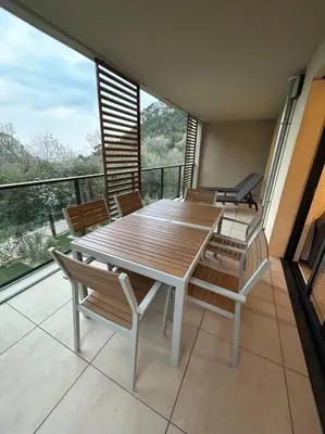 a wooden table and chairs on a balcony at Prestige View 411 By Avecoeur in Èze