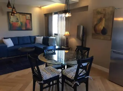 a living room with a blue couch and a glass table at Lovely Refurbished Apartment in Nice