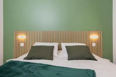 a bedroom with a large bed with two pillows at Modern Apartment - Promenade des Anglais in Nice in Nice