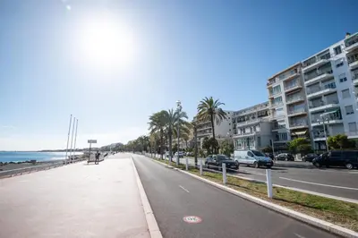 a street with cars parked on the side of a beach at Modern Apartment - Promenade des Anglais in Nice in Nice