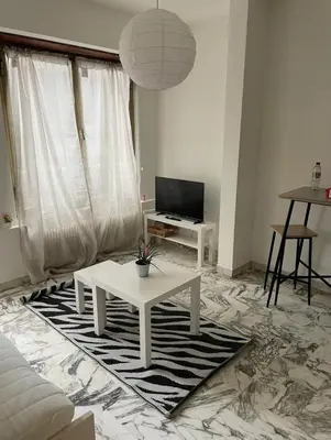 a living room with a white couch and a table at Studio 50 m de la mer - Centre - Proche mer in Nice