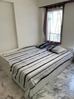 a large bed in a bedroom with a window at Studio 50 m de la mer - Centre - Proche mer in Nice