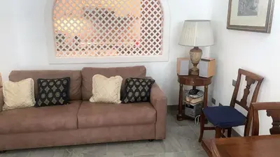 a living room with a brown couch and a table at Acquamarina - vue mer in Nice