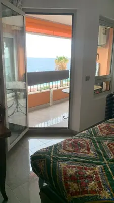 a bedroom with a view of the ocean through a mirror at Acquamarina - vue mer in Nice
