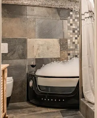 a bathroom with a tub and a toilet and a shower at Duplex, jacuzzi, terrasse sur les toits in Nice