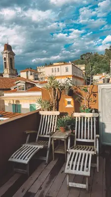 two chairs and a table on a balcony at Duplex, jacuzzi, terrasse sur les toits in Nice