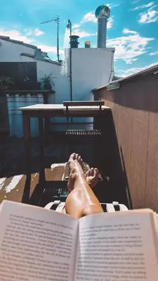 a person laying in a hammock reading a book at Duplex, jacuzzi, terrasse sur les toits in Nice