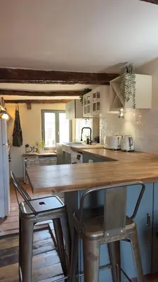 a kitchen with a wooden counter and chairs in it at Duplex, jacuzzi, terrasse sur les toits in Nice