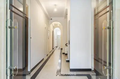 a hallway with white walls and black and white floors at Suite Flora Five stars Holiday house in Nice