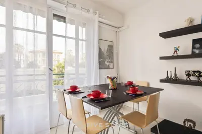 a dining room with a table and chairs and a window at Suite Flora Five stars Holiday house in Nice