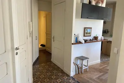 a hallway with a kitchen with a counter and a stool at Nice 56m with balcony in rotunda near the sea in Nice