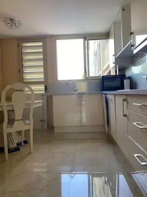 a kitchen with a sink and a table and a chair at Cagnes-sur-Mer, 50m de la mer, au calme in Cagnes-sur-Mer