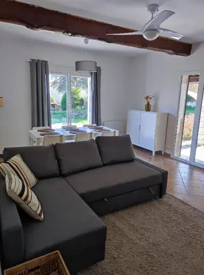 a living room with a black couch and a table at Villa Olivaie St Ange in La Gaude