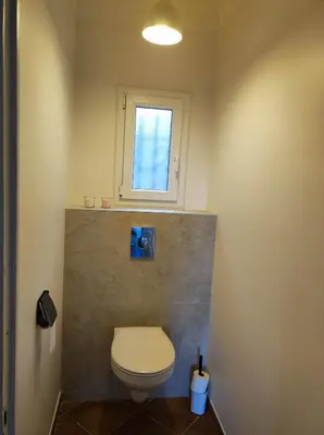 a bathroom with a toilet and a window at Villa Olivaie St Ange in La Gaude