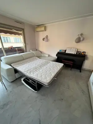 a bed in a room with a couch and a piano at Chambre privée avec terrasse au port de Nice in Nice