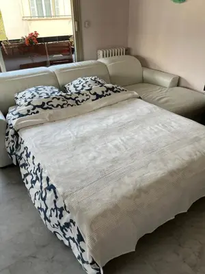 a large bed in a room with a couch at Chambre privée avec terrasse au port de Nice in Nice