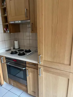 a kitchen with wooden cabinets and a stove top oven at Chambre privée avec terrasse au port de Nice in Nice