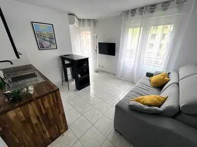 a living room with a couch and a television at Magnifique studio au bord de mer in Nice
