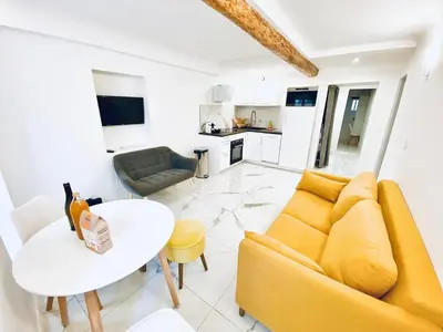 a living room with a yellow couch and a table at T3 carré d’or plein centre in Nice