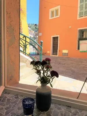a vase with flowers sitting on a table in front of a building at LA FONTAINE AP4355 By Riviera Holiday Homes in Villefranche-sur-Mer