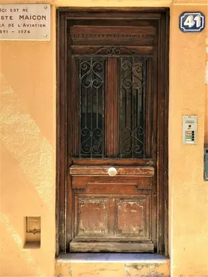 a wooden door on the side of a building at LA FONTAINE AP4355 By Riviera Holiday Homes in Villefranche-sur-Mer