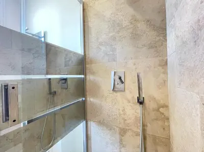 a bathroom with a shower with a glass door at Nice Renting - CAMBRAI02 - Studio Beach Sea View - AC - Promenade des Anglais in Nice