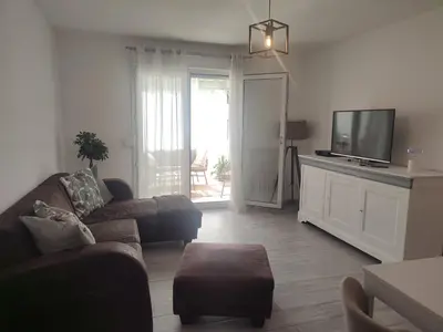a living room with a couch and a flat screen tv at Superbe appartement avec piscine l'été de juin à septembre in Nice