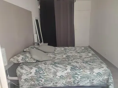 a bedroom with a bed with a blanket and pillows at Superbe appartement avec piscine l'été de juin à septembre in Nice