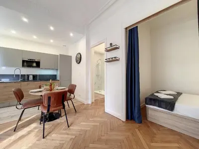 a room with a table and a bed and a kitchen at Nestor&Jeeves - LE NICOIS - Central in Nice
