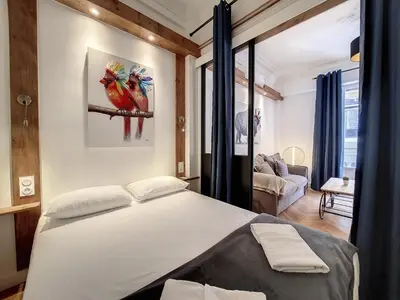 a bedroom with a bed and a living room at Nestor&Jeeves - LE NICOIS - Central in Nice