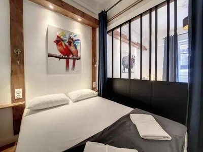 a bedroom with a bed and a window at Nestor&Jeeves - LE NICOIS - Central in Nice