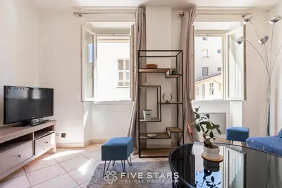 a living room with a tv and blue chairs at Suite La bohème Five stars Holiday house in Nice