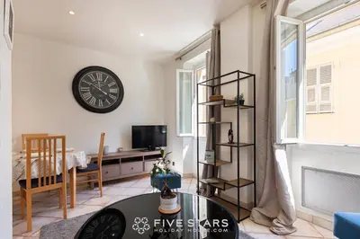 a living room with a clock on the wall and a table at Suite La bohème Five stars Holiday house in Nice