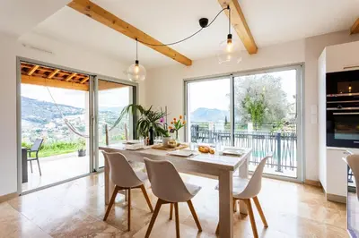a dining room with a table and chairs and large windows at LA CASITA VI4348 By Riviera Holiday HOmes in Falicon