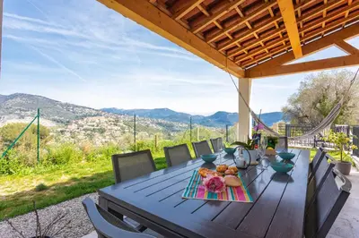 a wooden table with a plate of food on it at LA CASITA VI4348 By Riviera Holiday HOmes in Falicon