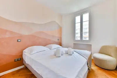 a bedroom with a large bed and a chair at Happyfew Palazzo del sol in Nice