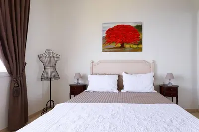 a bedroom with a white bed and a red tree at Sea View Apartment with Private Secure Parking - 2 in Villefranche-sur-Mer