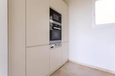a kitchen with white cabinets and a microwave at Sea View Apartment with Private Secure Parking - 2 in Villefranche-sur-Mer