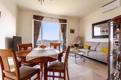 a living room with a table and a couch at Sea View Apartment with Private Secure Parking - 2 in Villefranche-sur-Mer