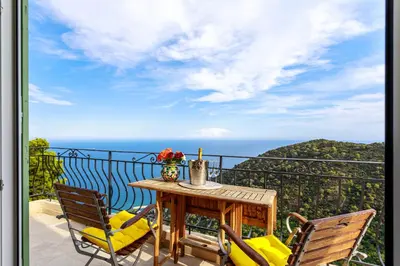a table and chairs on a balcony with the ocean at Sea View Apartment with Private Secure Parking 3 in Villefranche-sur-Mer