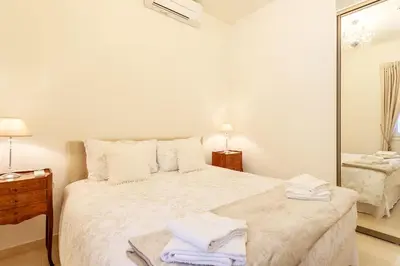 a white bedroom with a large bed and a mirror at Sea View Apartment with Private Secure Parking 3 in Villefranche-sur-Mer