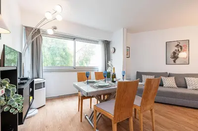 a living room with a table and chairs and a couch at Central 1 Bdr in Nice