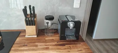 a coffee maker sitting on a wooden floor next to knives at LA MAÏOUN DI JOSE - Appt 2 pièces nice centre cœur marché de la libération in Nice