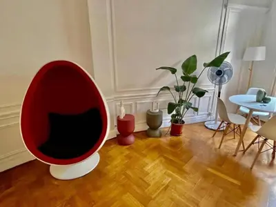a living room with a red chair and a table at Luxurious 2 bedrooms on Promenades des Anglais in Nice