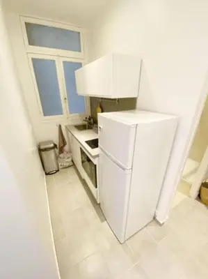 a small kitchen with a white refrigerator and a window at Luxurious 2 bedrooms on Promenades des Anglais in Nice