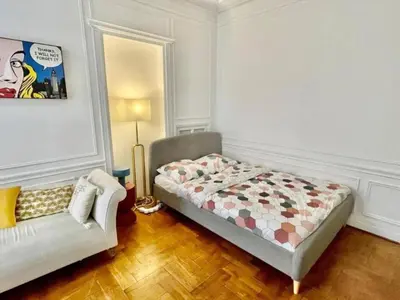 a bedroom with a bed and a couch in it at Luxurious 2 bedrooms on Promenades des Anglais in Nice
