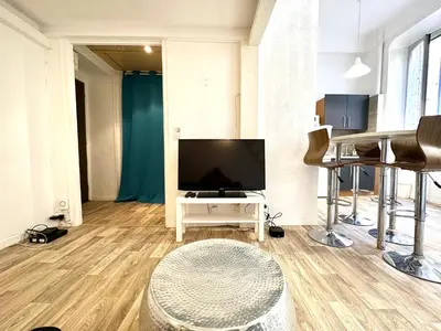 a living room with a flat screen tv and a table at Studio mezzanine sur le port in Nice