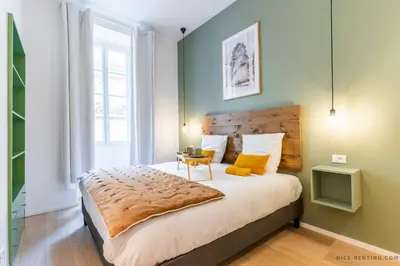 a bedroom with a large bed with a wooden headboard at Nice Renting - BAVASTRO - Luxurious Loft - 2 BedRoom - AC - Balcony - Trendy Neighborhood in Nice