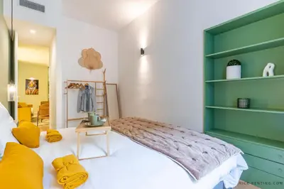 a bedroom with a bed with a green headboard at Nice Renting - BAVASTRO - Luxurious Loft - 2 BedRoom - AC - Balcony - Trendy Neighborhood in Nice